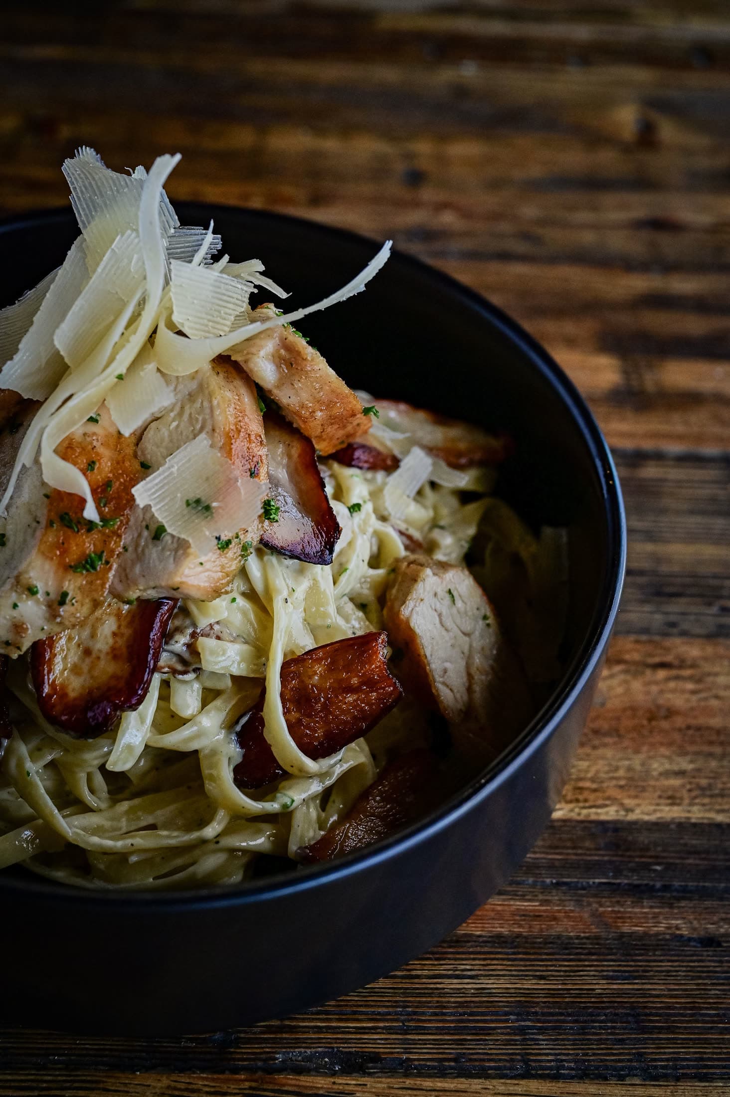 Creamy pasta topped with chicken, crispy bacon, and parmesan