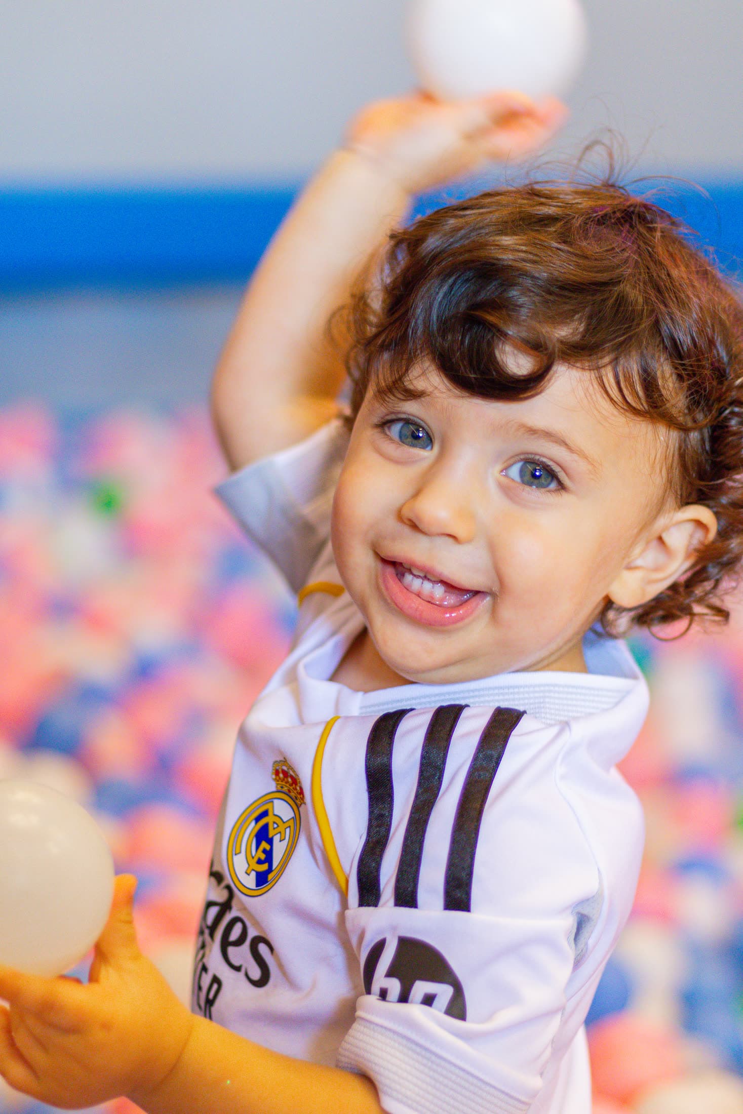 Toddler smiling in the Bambini Land ball pit